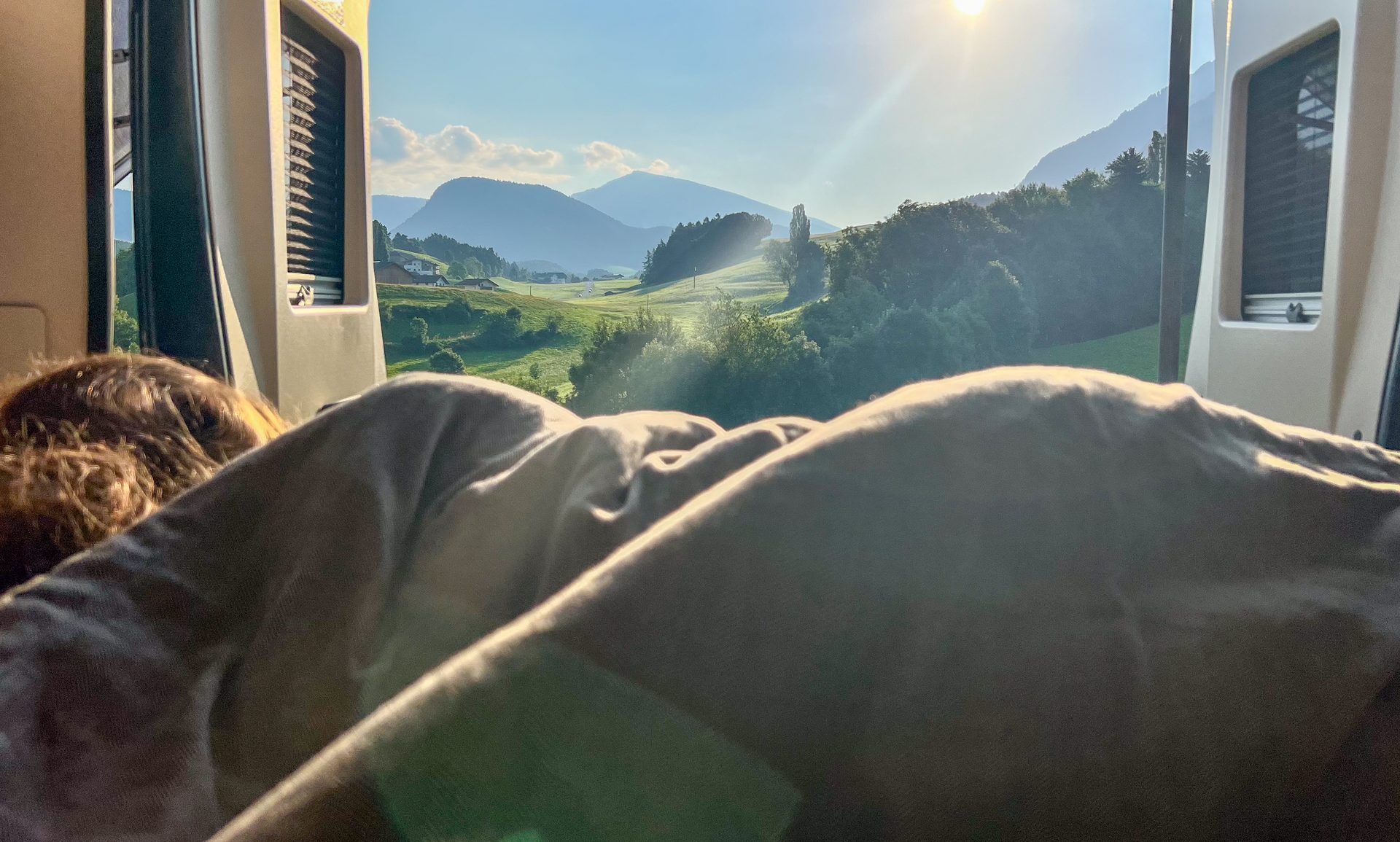 Ochtendzon en bergzicht vanuit het bed in camper Freddy