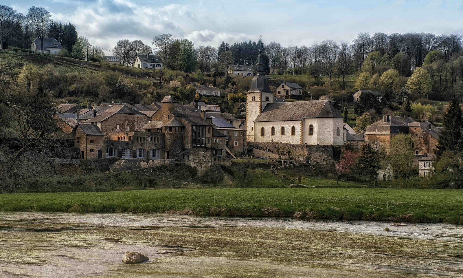 Rivier in een Ardense vallei met bossen aan weerszijden